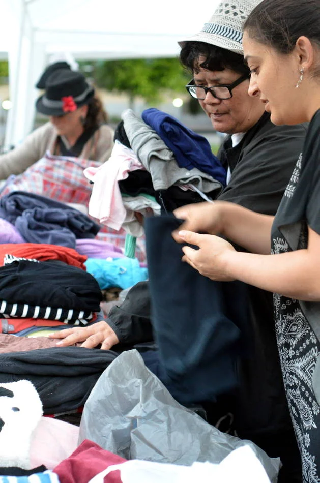 Sorting donated clothes with strangers at dusk. The work is unglamorous and the photographs of it are among my most honest.