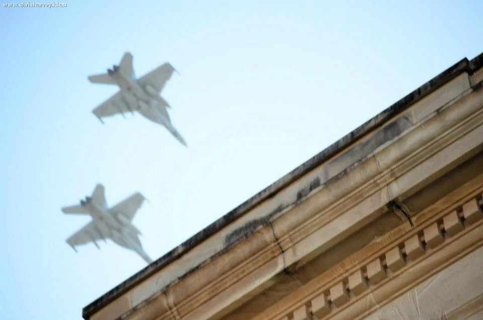 Two jets in formation over a sandstone corner. The contrast between the heritage building and modern aircraft is the kind of collision ANZAC Day produces every year.
